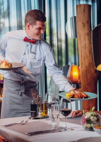 A waiter serving food to his guests