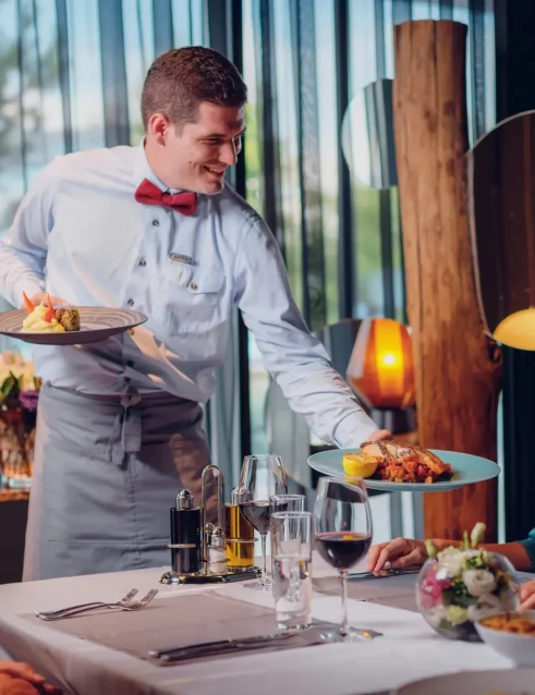 A waiter serving food to his guests